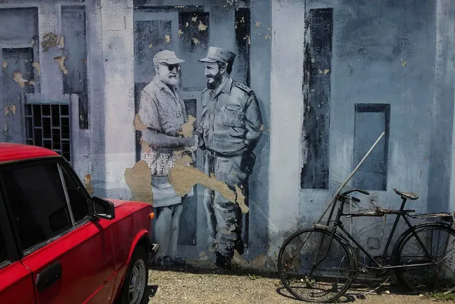 In this Monday, June 22, 2015 photo, a mural of author Ernest Hemingway and Fidel Castro shaking hands covers a downtown parking lot in Havana, Cuba. (Photo by Ramon Espinosa/AP Photo)