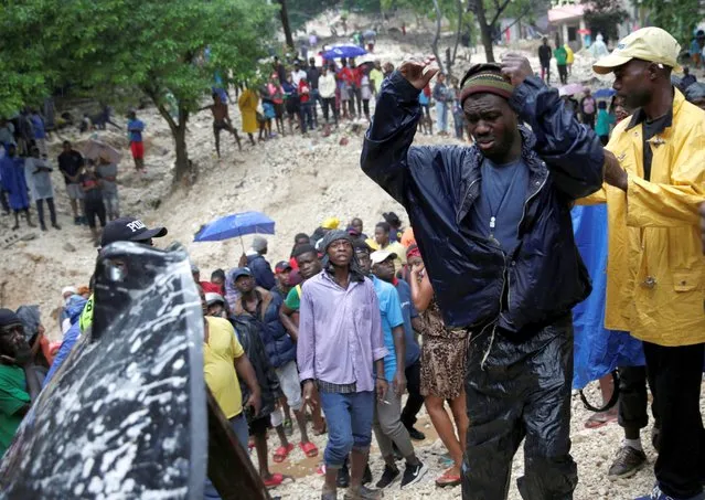 A man reacts in front of the body of his mother, who died during the passage of Tropical Storm Laura, in Port-au-Prince, Haiti on August 23, 2020.  Out of the Caribbean islands Laura caused the most damage in Haiti, where preparedness is weak while deforestation has left the country vulnerable to flooding and landslides when there are heavy rains. (Photo by Andres Martinez Casares/Reuters)
