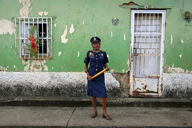A woman wearing a vintage police uniform stands for a portrait during the celebration of Holy Innocents Day in Caucagua, Miranda state, Venezuela, on December 28, 2022. (Photo by Federico Parra/AFP Photo)