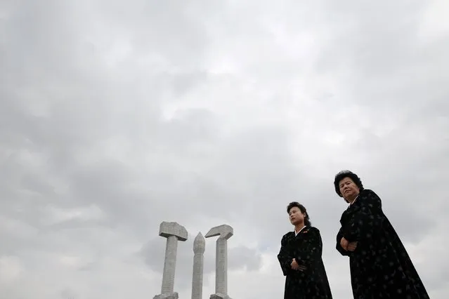 Official guides stand under the Monument to the Foundation of the Workers' Party as it's visited by foreign reporters on a government organised tour in Pyongyana, North Korea, October 11, 2015. Isolated North Korea marked the 70th anniversary of its ruling Workers' Party on Saturday with a massive military parade overseen by leader Kim Jong Un, who said his country was ready to fight any war waged by the United States. (Photo by Damir Sagolj/Reuters)