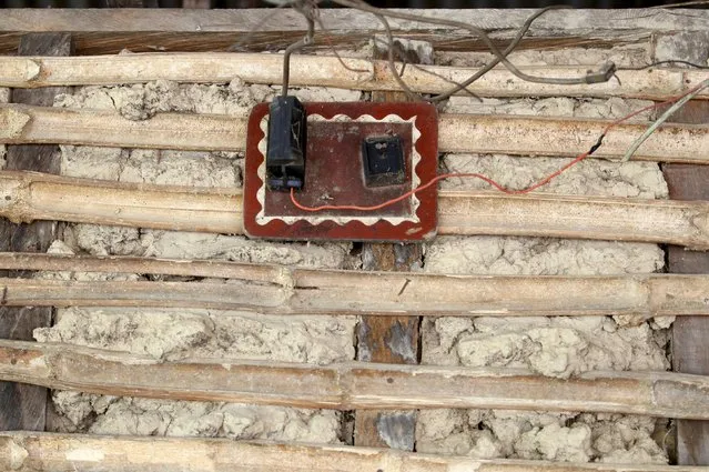 A wired switch is seen nailed to the wall outside a mud house in Ikarama village on the outskirts of the Bayelsa state capital, Yenagoa, in Nigeria's delta region October 8, 2015. (Photo by Akintunde Akinleye/Reuters)