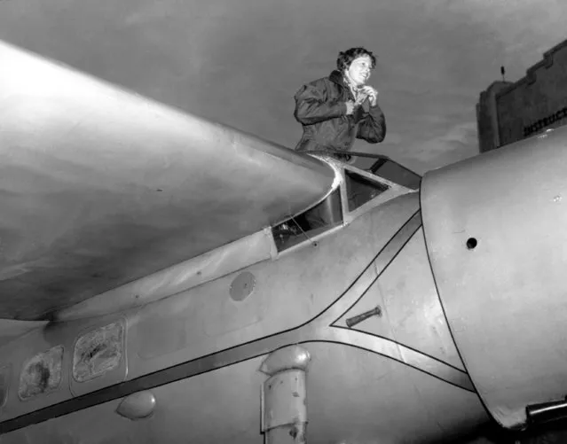 American aviatrix Amelia Earhart climbs from the cockpit of her plane at Los Angeles, Ca., January 13, 1935 after a flight from Oakland to visit her mother.  It is the plane she had flown into Oakland the day before from the Hawaiian Islands, becoming the first woman to fly solo across the Pacific Ocean. (Photo by AP Photo)