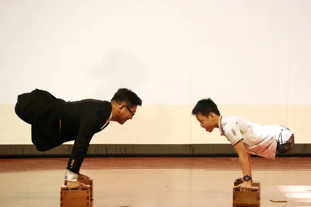 Gao Zhiyu (R) and Chen Zhou, who lost both of their legs in accidents, perform as they give a speech at a university in Qingdao, Shandong province, China, September 11, 2016. (Photo by Reuters/Stringer)