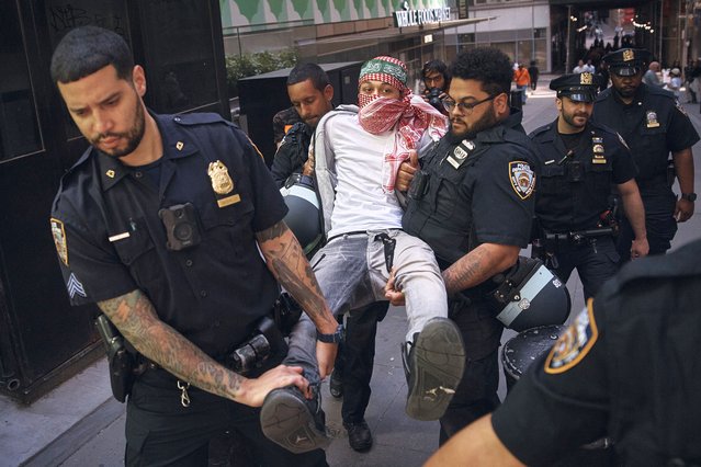 Police arrest a protester during a pro-Palestinian demonstration calling for an economic blockade and demanding a cease-fire on the Israel-Palestinian conflict outside The New York Stock Exchange on Monday, April 15, 2024, in New York. (Photo by Andres Kudacki/AP Photo)