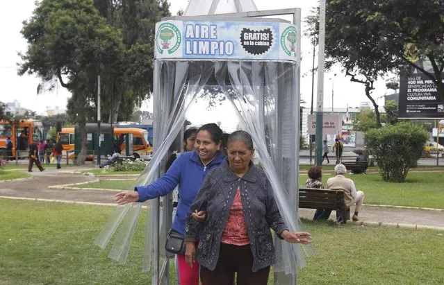 People leave a giant air purifier, which its inventor calls a “super tree”, in Lima's district of Jesus Maria November 24, 2014. (Photo by Mariana Bazo/Reuters)