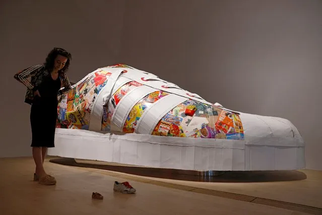 French artist “smoluk”, who is based in Canada, stands next to her recycled cardboard sneaker sculpture “The Super Large Superstar”, during the media preview of Sneakertopia, a sneaker and street culture exhibition, at the Art Science Museum in Singapore on February 23, 2023. (Photo by Edgar Su/Reuters)