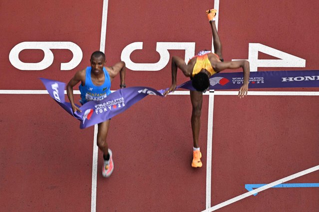 Germany's athlete Amanal Petros (R) falls as he crosses the finish line behind Tanzania's athlete Alphonce Felix Simbu (L) in the men's marathon final during the World Athletics Championships in Tokyo on September 15, 2025. (Photo by Antonin Thuillier/AFP Photo)