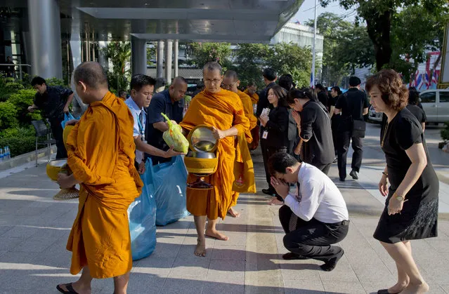 Thai mourners participate in Buddhist merit making ceremonies, a day after the cremation of late Thai King Bhumibol Adulyadej in Bangkok, Thailand Friday, October 27, 2017. With solemn faces and outright tears, Thais said farewell to their king and father figure with elaborate funeral ceremonies that cap a year of mourning and are steeped in centuries of tradition. (Photo by Gemunu Amarasinghe/AP Photo)