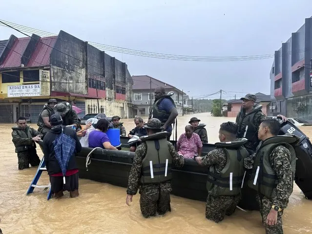 In this photo released by National Disaster Management Agency, the army evacuate residents on Chaah town in Segamat, in southern Johor state, Malaysia, Wednesday, March 1, 2023. Rescuers in boats plucked flood victims trapped on rooftops and hauled others to safety as incessant rain submerged homes and villages in parts of Malaysia, leading to over 26,000 people evacuated as of Thursday. (Photo by National Disaster Management Agency via AP Photo)