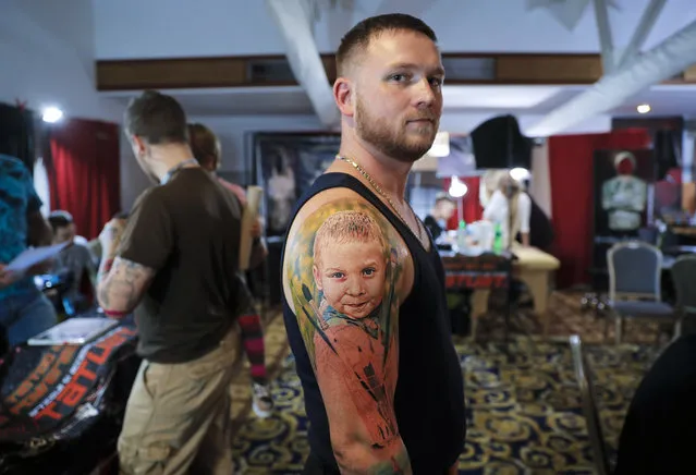 Serghei, from the Republic of Moldova, poses with a fresh tattoo showing his son Chiril, during the International Tattoo Convention Bucharest 2016 in Bucharest, Romania, Sunday, October 16, 2016. (Photo by Vadim Ghirda/AP Photo)