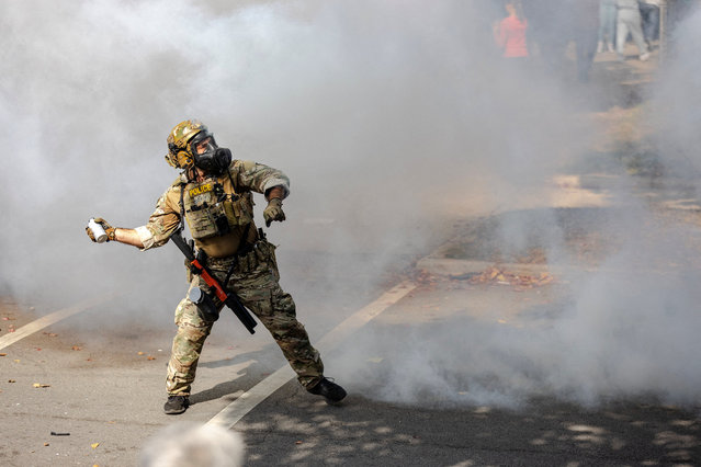 A federal agent throws a tear gas canister during clashes with community members on Chicago’s South Side, on October 14, 2025. (Photo by Jim Vondruska/Reuters)