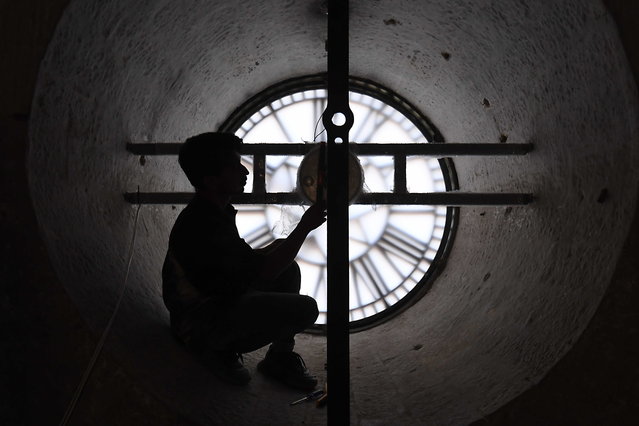 A local craftsman works on the dial of the historic clock tower at Empress Market in Karachi, Pakistan, 30 October 2025. Built in 1889 during the British Raj to honor Queen Victoria, the Indo-Gothic clock tower made of Gizri sandstone once guided colonial Karachi with its 153-kilogram bell, serving as a vital timekeeper when personal watches�were�a�rarity. (Photo by Shahzaib Akber/EPA)