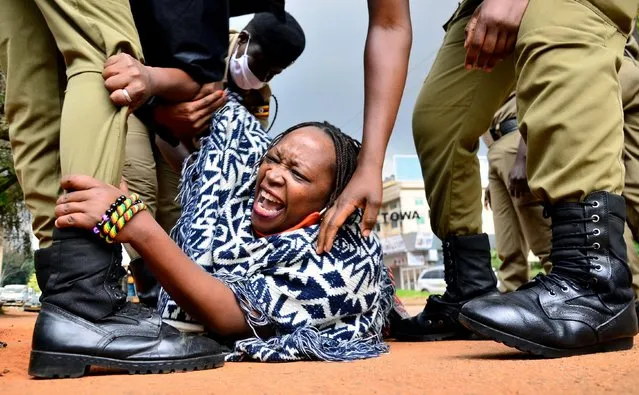 Stella Nyanzi (C), a prominent Ugandan activist and government critic, is arrested by police officers as she organised a protest for more food distribution by the government to people who has been financially struggling by the nationwide lockdown imposed to curb the spread of the COVID-19 coronavirus in Kampala, on May 18, 2020. (Photo by Abubaker Lubowa/Reuters)