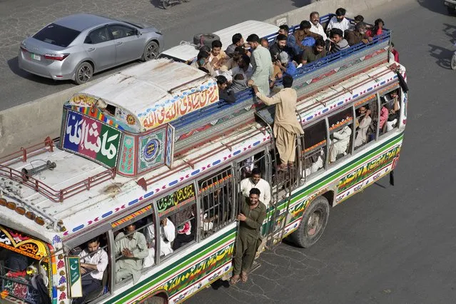 People travel on an over loaded bus to reach their villages and cities to celebrate the upcoming Eid al-Fitr holidays, marking the end of the Islamic holy month of Ramadan, in Lahore, Pakistan, Thursday, April 20, 2023.. (Photo by K.M. Chaudary/AP Photo)
