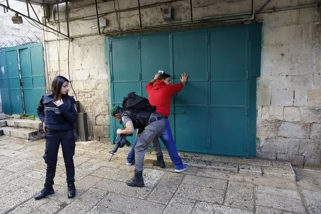 An Israeli border policemen checks on a Palestinian man at the area in Jerusalem's old city where an Israeli border police shot dead a Palestinian who stabbed an officer on Sunday, a police spokesman said, the latest attack in a two-month wave of violence, November 29, 2015. (Photo by Ronen Zvulun/Reuters)