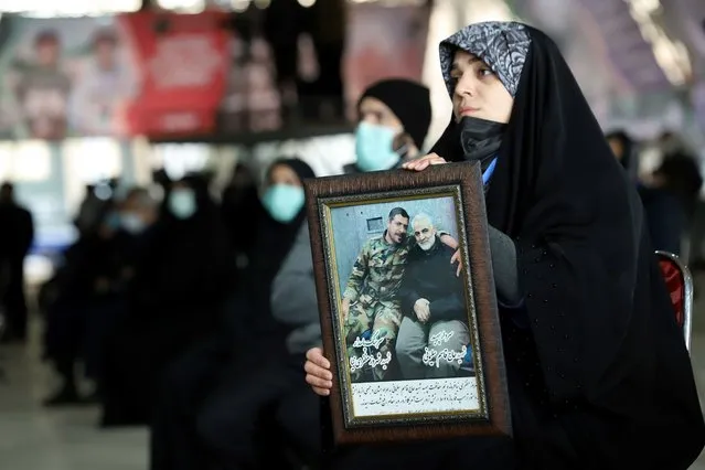 An Iranian woman holds a picture of Qassem Soleimani, during a ceremony to mark the one year anniversary of the killing of senior Iranian military commander General Qassem Soleimani in a U.S. attack, in Tehran, Iran, on January 1, 2021. (Photo by Majid Asgaripour/WANA via Reuters)