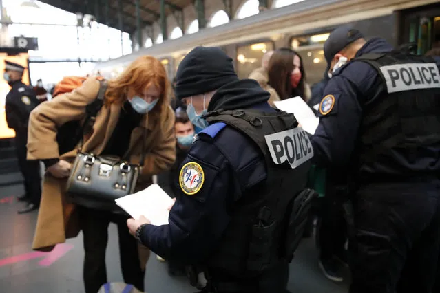 French police officers check passengers of a train from Amsterdam and Brussels at Gare du Nord station in Paris, Monday, February 1, 2021. France says it's closing its borders to people arriving from outside the European Union starting Sunday to try to stop the growing spread of new variants of the virus and avoid a third lockdown. (Photo by Francois Mori/AP Photo)