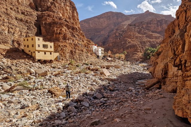 A man walks in a flood-devastated area of Tamanart in Morocco's Tata province on September 8, 2024. When powerful thunderstorms hit Morocco's arid south, they brought deadly floods but also provided some relief to farmers as the country grapples with its worst drought in nearly 40 years. (Photo by M'hand Oubarka/AFP Photo)