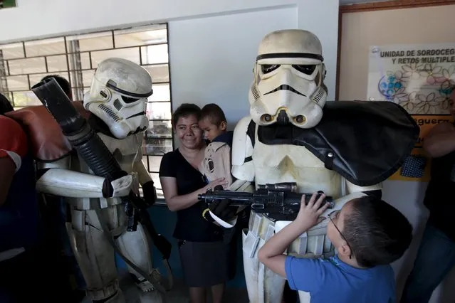 Blind children touch cosplayers dressed as storm troopers from the Star Wars movie series during a charity event organised by Star Wars fan club El Salvador, at the “Eugenia Duenas” Blind Rehabilitation Center in San Salvador, El Salvador, December 10, 2015. (Photo by Jose Cabezas/Reuters)