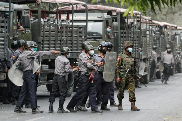 Police and soldiers are seen during a protests against the military coup, in Mandalay, Myanmar, February 20, 2021. (Photo by Reuters/Stringer)