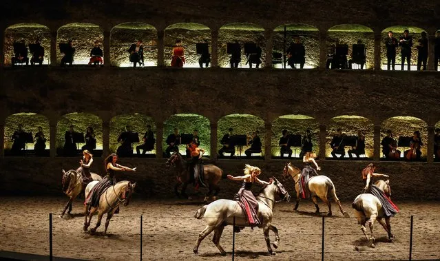 Horses and riders perform on stage during a dress rehearsal of Wolfgang Amadeus Mozart's cantata “Davide penitente” in Salzburg January 20, 2015. Salzburg's annual Mozart Week has something new this year. Along with the usual performances of music by Austria's most famous composer, it's got a ballet. (Photo by Dominic Ebenbichler/Reuters)