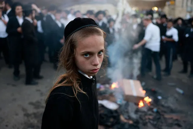 Ultra-Ortodox Jews take part in the annual pilgrimage to the grave site of Rabbi Shimon Bar Yochai in the northern Israeli village of Meron in the early hours of May 19, 2022 at the start of the day-long holiday of Lag Baomer that commemorates the second century Jewish scholar's death. Thousands of Jewish faithful lit large bonfires all night long after converging on Mount Meron for the annual pilgrimage, amid tightened safety measures a year after 45 people were crushed to death in a stampede at the spot. On April 30 last year, a stampede broke out in the male section of the gender-divided site as the size of the crowd turned a narrow passageway into a deadly choke-point. (Photo by Menahem Kahana/AFP Photo)