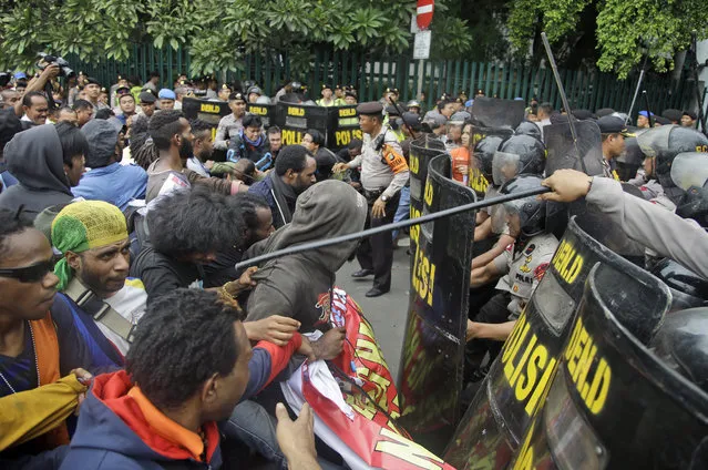 West Papuan protesters scuffle with the police during a rally calling for the remote region's independence, in Jakarta, Indonesia, Thursday, December 1, 2016. Dozens of demonstrators were blocked from marching onto a busy traffic circle in the capital by several hundred police who fired water cannons and dragged men from the crowd into waiting police vans. (Photo by Dita Alangkara/AP Photo)