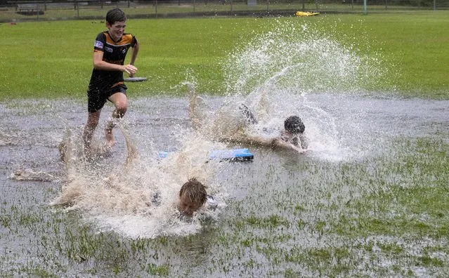 Children play in a flooded park at Port Stephens, 200 kilometers (124 miles) north of Sydney, Australia, Saturday, March 20, 2021. The Bureau of Meteorology issued a severe weather warning for people across New South Wales and to expect intense rain and potentially life-threatening flooding to the Mid North Coast, Hunter, Sydney, Illawarra, and parts of the Central and Southern Tablelands. (Photo by Mark Baker/AP Photo)