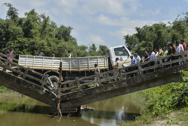 Indian rescue workers and villagers gather near a collapsed bridge in Phasidewa village near the India-Bangladesh border on the outskirts of Siliguri in the Indian state of West Bengal on September 7, 2018. No casualties were reported in the collapse. (Photo by Diptendu Dutta/AFP Photo)