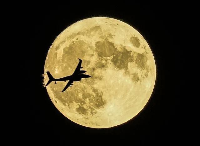 Akıncı unmanned aerial craft passes in front of the Supermoon during a demonstration flight on the first day of Teknofest technology and aerospace festival in Ankara, Turkey, Wednesday, August 30, 2023. (Photo by Emrah Gurel/AP Photo)