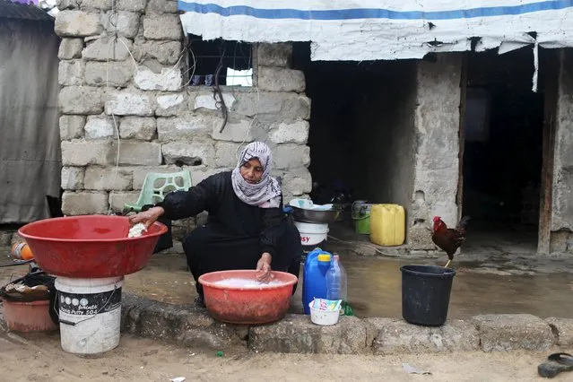 A Palestinian woman washes clothes at her dwelling in Khan Younis in the southern Gaza Strip, December 1, 2015. (Photo by Ibraheem Abu Mustafa/Reuters)