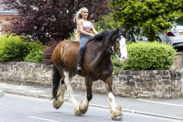 A woman rides her horse through the street on the first day of the Appleby Horse Fair on June 9, 2022. Appleby Horse Fair is an annual gathering of Travellers & Gypsies in the town of Appleby in Cumbria & attracts roughly 10,0000 Travellers & about 30,000 visitors over the three day period it is held. (Photo by Andrew McCaren/London News Pictures)