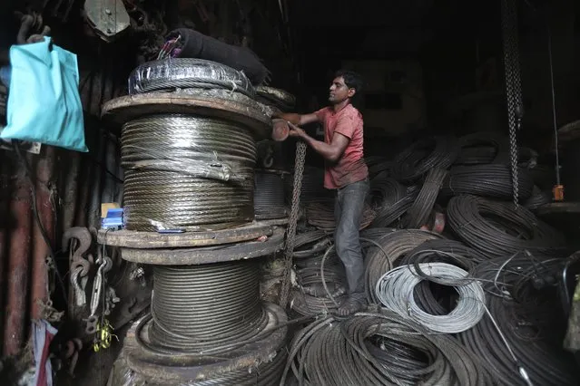 A man works in an iron and steel scrap workshop in Mumbai, India, Friday, June 11, 2021. India’s economy was on the cusp of recovery from the first pandemic shock when a new wave of infections swept the country, infecting millions, killing hundreds of thousands and forcing many people to stay home. Cases are now tapering off, but prospects for many Indians are drastically worse as salaried jobs vanish, incomes shrink and inequality is rising. (Photo by Rafiq Maqbool/AP Photo)