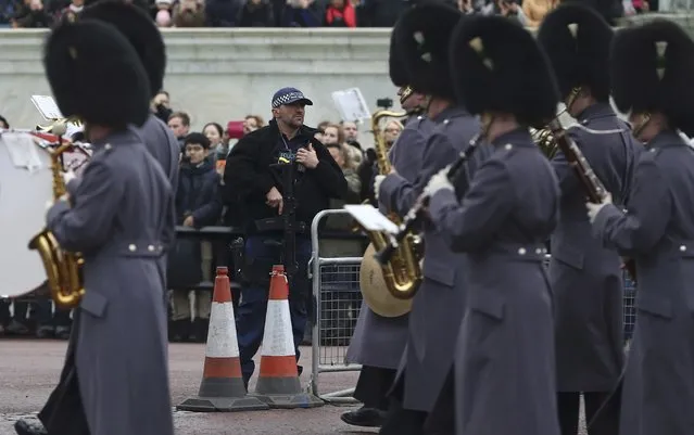An armed police officer patrols as the Irish Guards take part in the Changing of the Guard ceremony at Buckingham Palace in London, Britain December 21, 2016. (Photo by Neil Hall/Reuters)