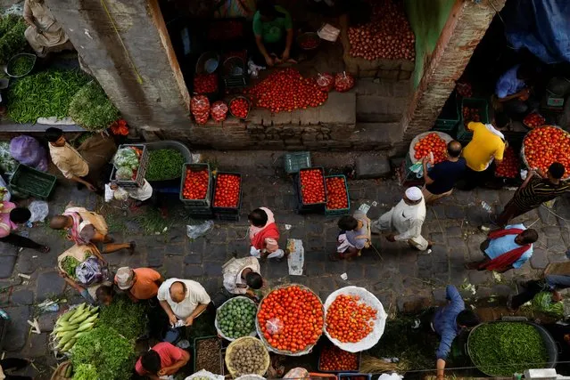 People shop at a crowded wholesale vegetable market after authorities eased coronavirus restrictions, following a drop in the coronavirus disease (COVID-19) cases, in the old quarters of Delhi, India, June 23, 2021. (Photo by Adnan Abidi/Reuters)