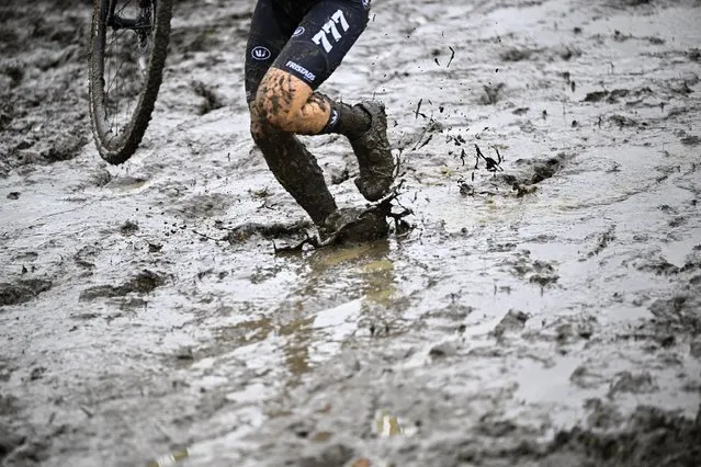 A competitor walks in the mud carrying her bike during the women elite race of the Koppenbergcross, the first race (out of eight) of the X2O Badkamers trophy cyclocross competition, in Melden, Oudenaarde, on November 1, 2023. (Photo by Jasper Jacobs/Belga via AFP Photo)