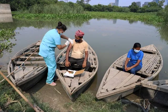 A health worker administers a vaccine for COVID-19 to a boatman on an island in the River Yamuna in New Delhi, India, Friday, July 16, 2021. (Photo by Amit Sharma/AP Photo)