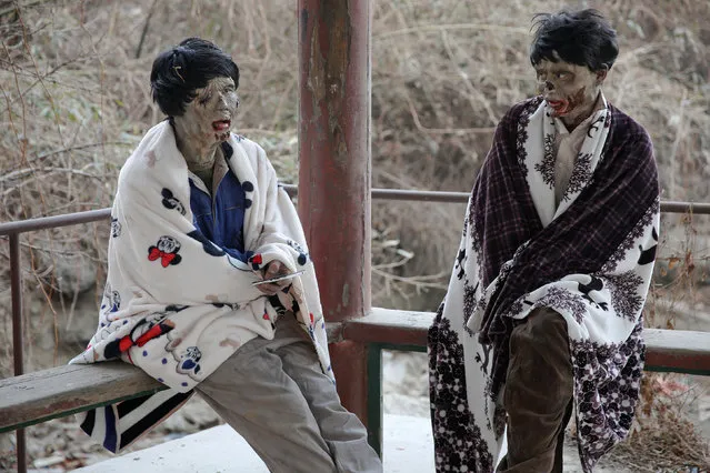 Actors wrapped in blankets react at the set of the post-apocalyptic movie Zombie Era at an abandoned factory complex in Langfang, Hebei province, China December 16, 2016. (Photo by Damir Sagolj/Reuters)