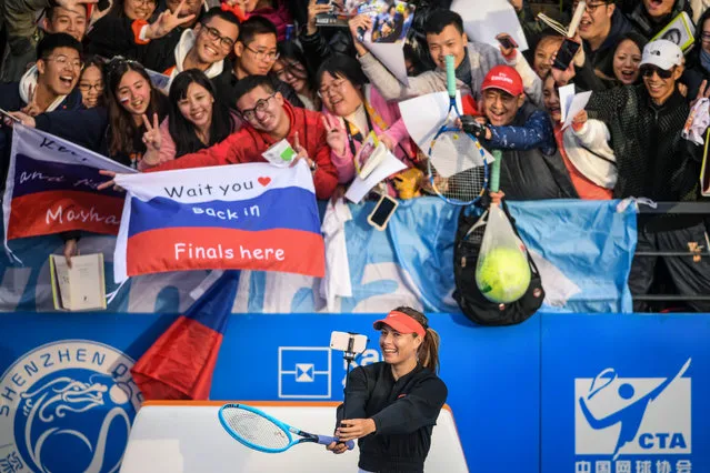 Maria Sharapova (bottom) of Russia takes a selfie with fans after her women's singles first round match against Timea Bacsinszky of Switzerland at the Shenzhen Open tennis tournament in Shenzhen in China's southern Guangdong province on December 31, 2018. (Photo by AFP Photo/Stringer)