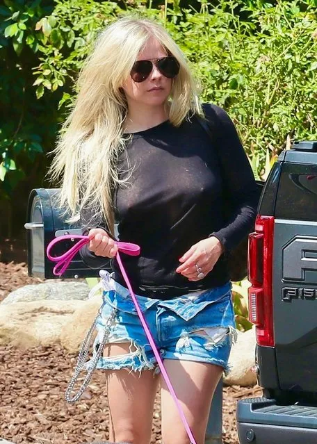 Canadian singer Avril Lavigne leaves little to the imagination wearing a see-through top as she and boyfriend Mod Sun arrive at a friend's house in Calabasas, CA. with Avril's dog on July 14, 2021. (Photo by Backgrid USA)