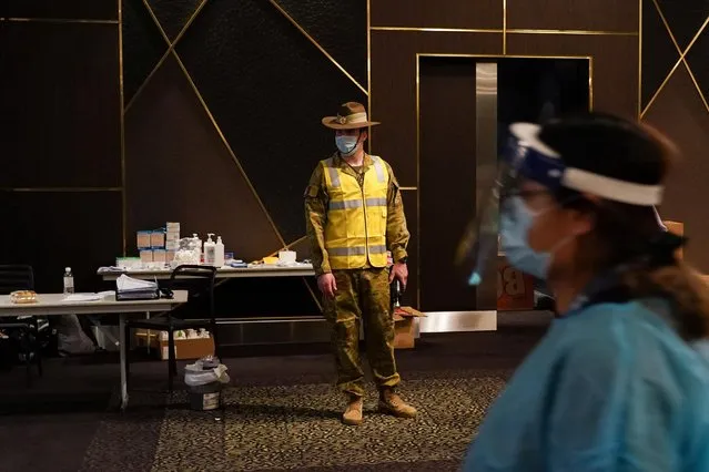 An Australian Defence Force member watches over a coronavirus disease (COVID-19) vaccination clinic at the Bankstown Sports Club as the city experiences an extended lockdown, in Sydney, Australia, August 3, 2021. (Photo by Loren Elliott/Reuters)