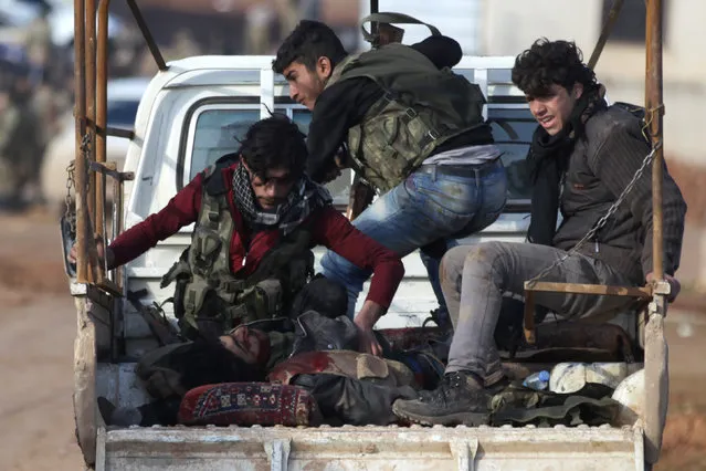 Free Syrian Army fighters ride on a pick-up truck with a fellow fighter, who was injured during an offensive against Islamic State fighters to take control of Qabasin town, on the outskirts of the northern Syrian town of al-Bab, Syria January 10, 2017. (Photo by Khalil Ashawi/Reuters)