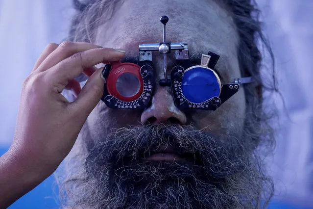 A Sadhu or a Hindu holy man gets his eyes tested at a free eye-care camp at a makeshift shelter before heading for an annual trip to Sagar Island for the one-day festival of “Makar Sankranti”, in Kolkata, India, January 10, 2019. (Photo by Rupak De Chowdhuri/Reuters)