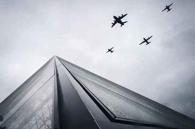 An Airbus A400M Atlas (ahead), next to Lockheed Martin C-130J Super Hercules (last) and two CASA CN-235 fly over the Louvre Pyramid during the annual Bastille Day military parade on the Champs-Elysees avenue in Paris on July 14, 2021. (Photo by Lucas Barioulet/AFP Photo)