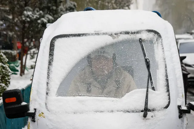 A man rides an electric rickshaw covered in snow during a snowfall in Beijing, China on December 13, 2023. Authorities have suspended schools, highways and some train services in Beijing and northern China as the country continues to experience snowfall and low temperature. According to the China Meteorological Administration, the snowfall and low temperature will continue until 15 December 2023. (Photo by Mark R. Cristino/EPA/EFE)