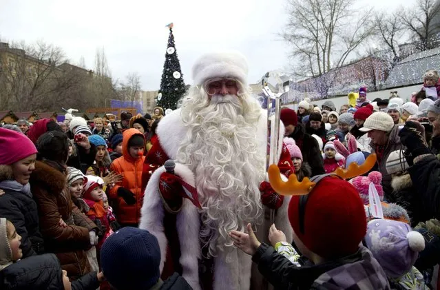 Children surround Russian Ded Moroz (Father Frost), who arrived in Moscow Zoo, as a part of a New Year celebrations, in Moscow, Russia, on Wednesday, December 25, 2013. Russians celebrate Orthodox Christmas on Jan. 7. (Photo by Ivan Sekretarev/AP Photo)