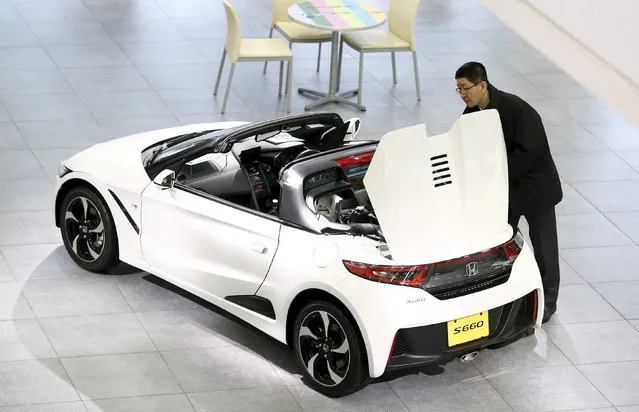 A man looks at a Honda S660 car at the showroom of the Honda Motor Co headquarters in Tokyo, Japan,  February 24, 2016. Nearly a year into his job, Honda Motor Co CEO Takahiro Hachigo plans a back-to-the-future shift at the Japanese automaker, driving clearer demarcation lines between those who develop cars and those who sell them, two senior company insiders told Reuters. (Photo by Thomas Peter/Reuters)