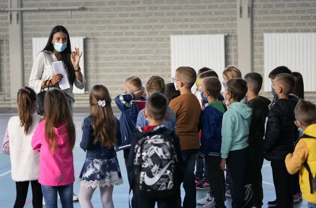 In this September 1, 2021, file photo, a teacher speaks to students on their first day back, at a primary school, in the village of Belegis, 25 kilometers west of Belgrade, Serbia. Children across Europe are going back to school, with hopes of a return to normality after 18 months of pandemic disruption and fears of a new surge in infections from the highly infectious delta variant of the coronavirus. (Photo by Darko Vojinovic/AP Photo/File)