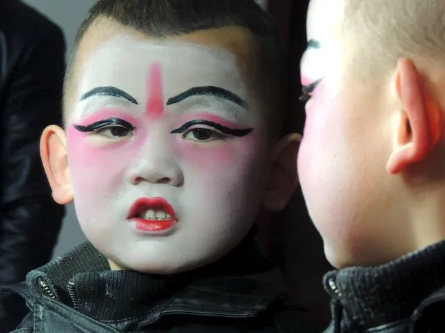 A boy wearing make-up for a traditional folk art show is seen reflected in a mirror in Xining, Qinghai Province, China, February 20, 2016. (Photo by Reuters/Stringer)