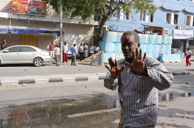 An unidentified injured man reacts as he walks from the scene of an explosion in front of Dayah hotel in Somalia's capital Mogadishu, January 25, 2017. (Photo by Feisal Omar/Reuters)